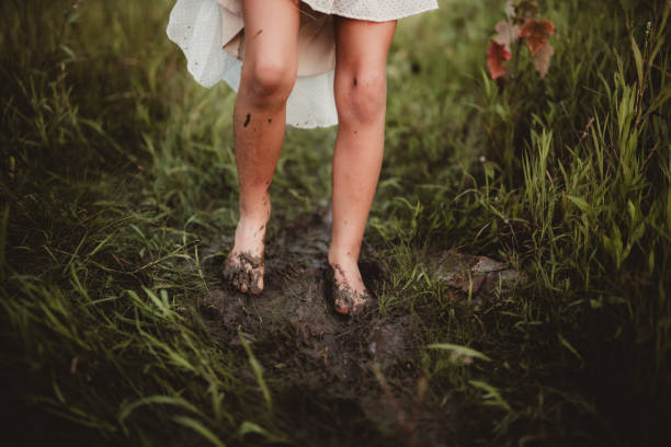 istock Little girl walking through the wet mud 1964302443
