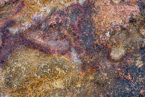 stone texture. Rough, unprocessed red and orange stone surface. Natural, earthy tones vibrant backdrop. Ideal for background. Textured, raw, and visually striking.