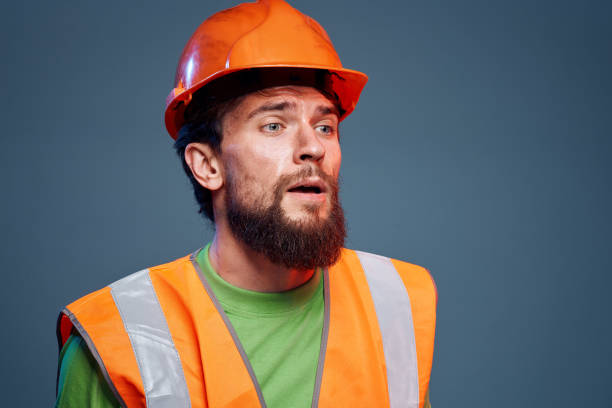 istock Angry man in work uniform orange paint safety hard work cropped view 1964321760