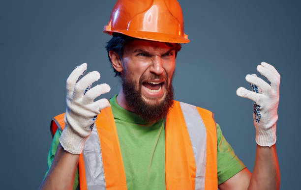 istock Male worker in orange paint emotions construction studio 1964322958