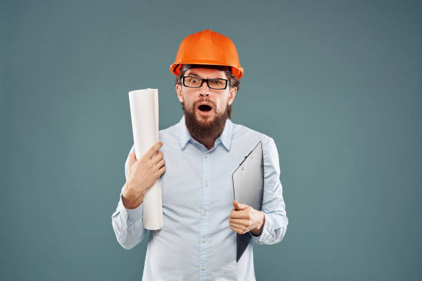 istock Man in shirt with blueprints in hands construction professional emotions cropped view 1964325557