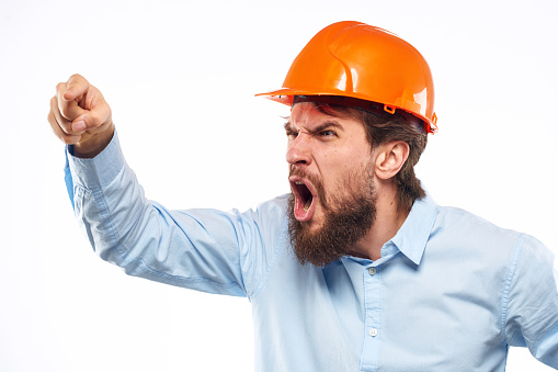 Angry man in orange hard hat industry work dissatisfaction cropped view. High quality photo