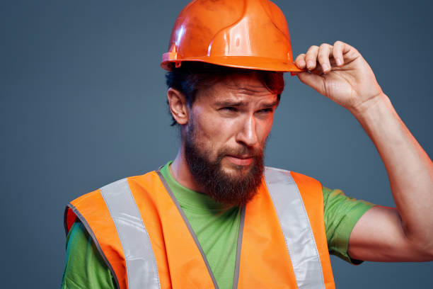 istock Angry man in work uniform orange paint safety hard work cropped view 1964337632