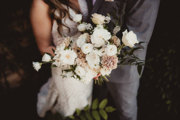 istock Bride and groom holding white wedding bouquet 1964363616