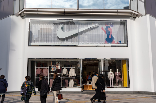 Kobe, Japan - January 19, 2024 : Pedestrians walk past the Nike store in Kobe, Hyogo Prefecture, Japan.