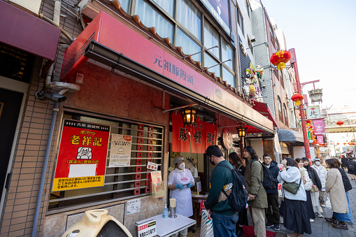 Kobe, Japan - January 19, 2024 : People queuing at the Roushouki Chinese steamed bun restaurant in Kobe Chinatown, Hyogo Prefecture, Japan.