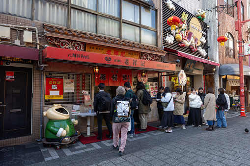 Kobe, Japan - January 19, 2024 : People queuing at the Roushouki Chinese steamed bun restaurant in Kobe Chinatown, Hyogo Prefecture, Japan.