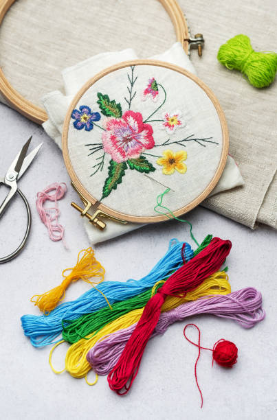 istock The process of hand embroidering a napkin with colored threads on white fabric. 1964531083