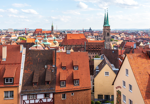 Nuremberg, Germany - August 22, 2023: Cityscape of the red tile roofs of the old town of Nuremberg with St. Sebald church (Sebalduskirche) and in the distance St. Lorenz church (Lorenzkirche).