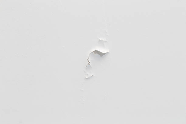 istock Cracked wall, Paint white peeling off an old interior wall, Grunge cracked white wall paint peeling off. 1964648840