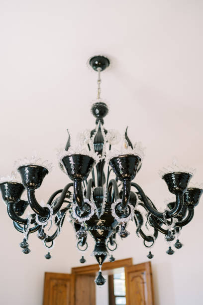 istock Black chandelier with openwork decor and pendants hangs from the ceiling 1964659730