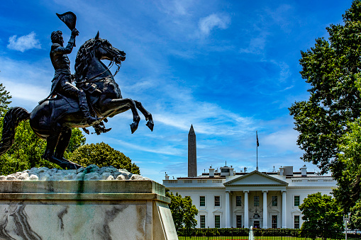 Statue of Andrew Jackson on horseback in Lafayette Square in front of the White House and the obelisk to the first president, in Washington DC, USA.