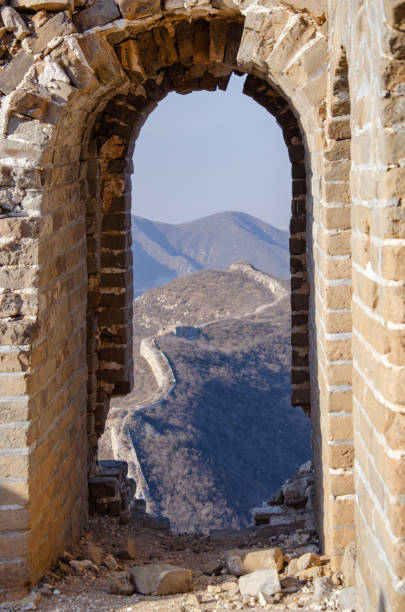 vecchia finestra in mattoni di un frammento della muraglia cinese. vista da un'antica finestra delle montagne nebbiose della grande muraglia cinese - chinese wall foto e immagini stock