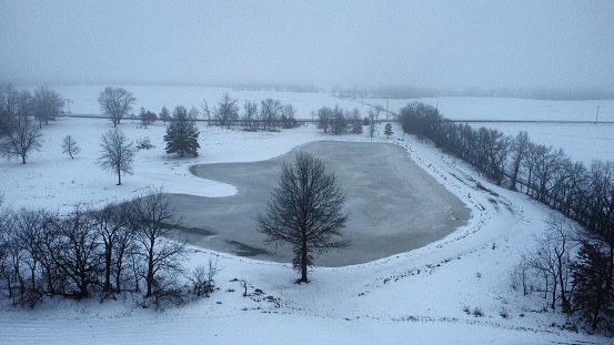 A farm pond frozen over in the bitter cold of a Midwestern winter