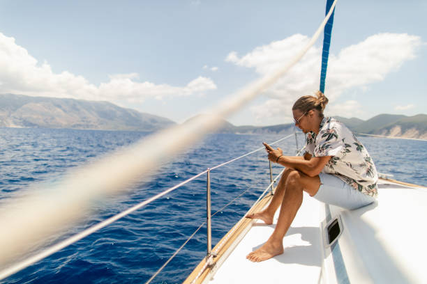 istock Young handsome man using phone on a sailboat 1964708637