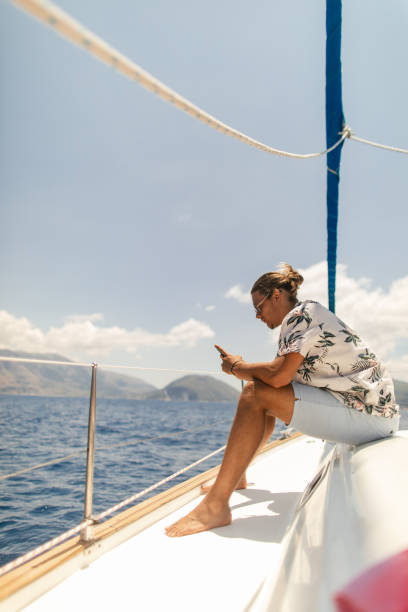 istock Young handsome man using phone on a sailboat 1964708639