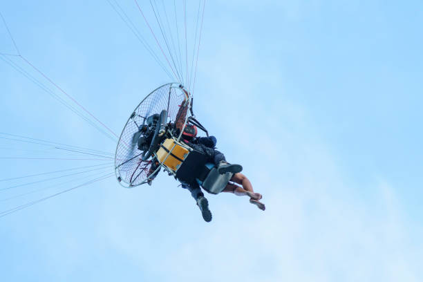 Paramotor pilot and his tourist client flying in the sky