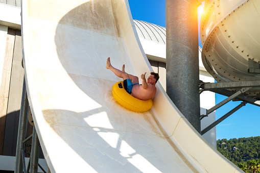 A man rides at high speed from a water slide water park.