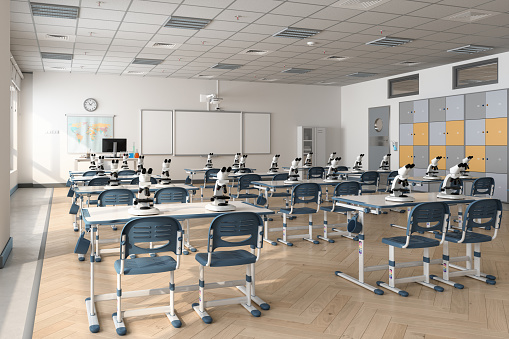 Empty Modern Classroom Interior With Microscopes On Desks, Blue Chairs, Cabinets And Whiteboard