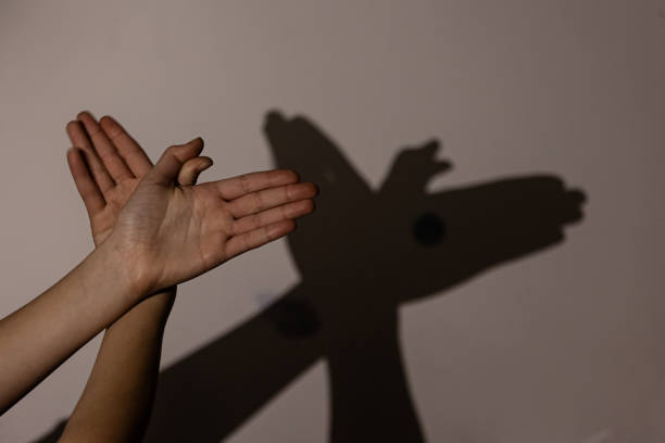 istock Child hands making bird on the wall, shadows, game with shadows on wall 1964781231