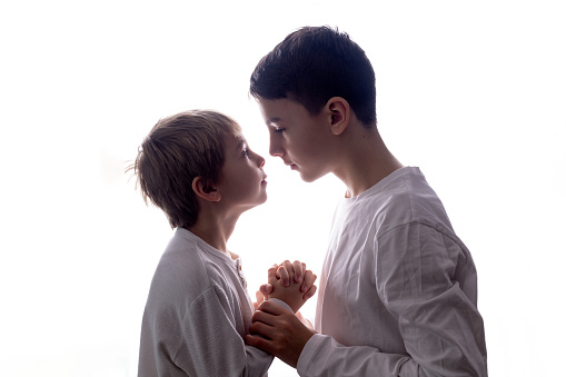 Isolated portrait on white background of siblings in studio, boys, holding hands