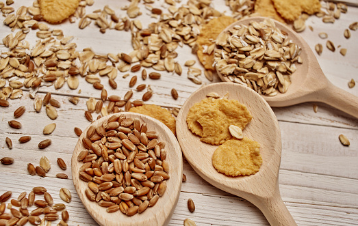 wheat and cereal scattered on the table wooden spoons kitchen board. High quality photo