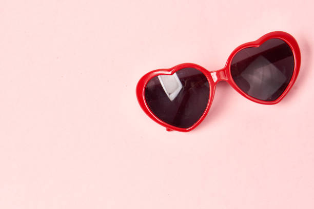 istock Heart shaped sunglasses with red frames on a pink background 1964799556