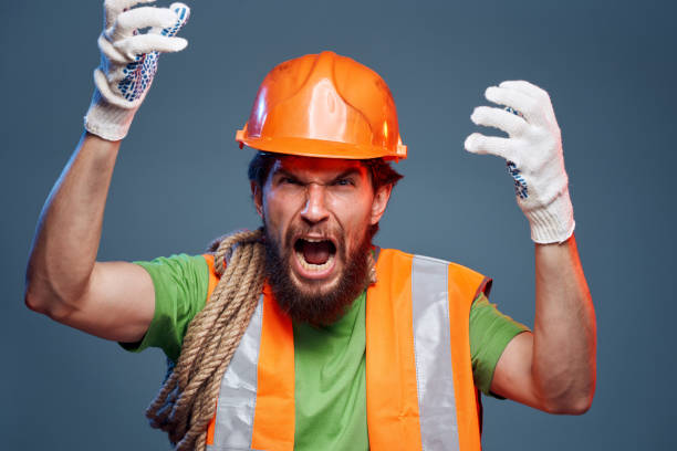 istock emotional man in work uniform safety professional blue background 1964821484