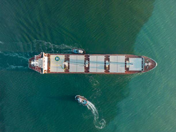 istock Aerial top view Tugboat pushing cargo ship to port. 1964862202