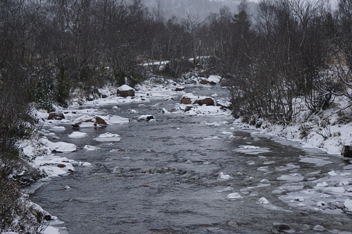 Small river in snow covered landscape.