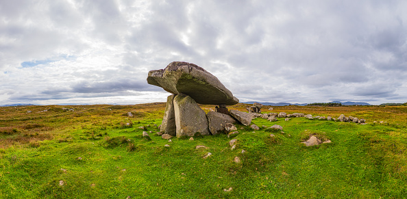 Kilclooney Dolmen is a Neolithic portal tomb located in County Donegal, Ireland. It is one of the finest examples of a portal tomb in Ireland and is estimated to be around 4000 to 4500 years old. The dolmen consists of a large capstone supported by three upright stones, creating a chamber that would have been used for burial purposes.