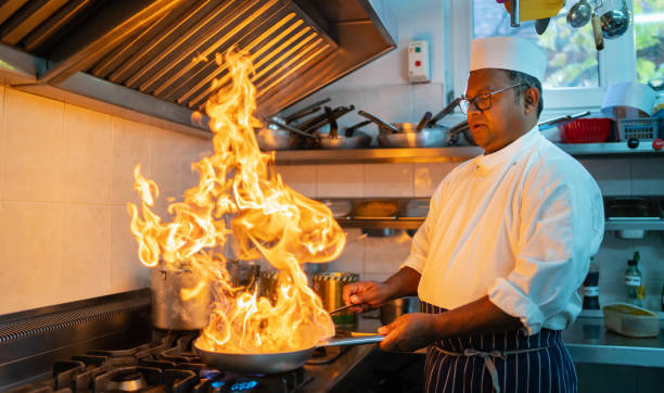 um chef está usando chamas escaldantes enquanto cozinha - asian ethnicity chef fine dining creativity - fotografias e filmes do acervo