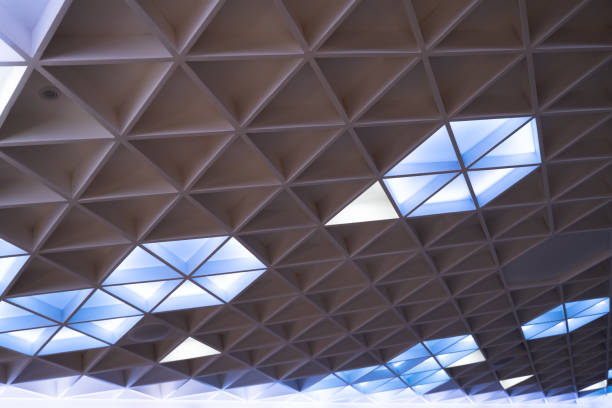 The illuminated ceiling of a modern design hotel seminar room has a geometric triangle shape.