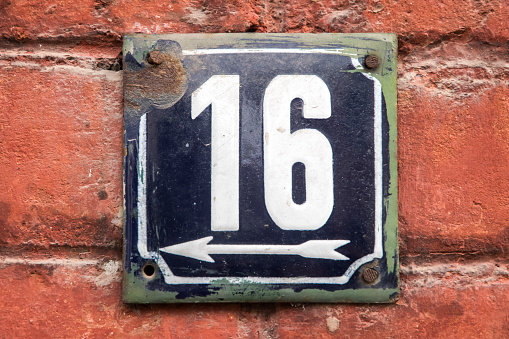 Weathered grunge square metal enameled plate of number of street address with number 16