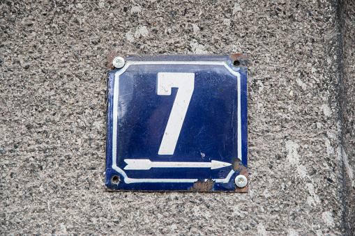 Weathered grunge square metal enameled plate of number of street address with number 7