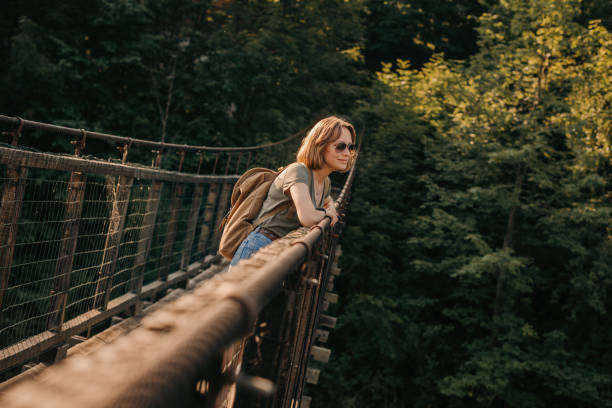 istock Young female traveler with backpack enjoying scenic view while standing on the bridge 1964984892