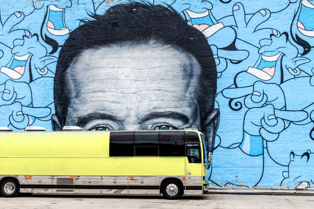 Chicago, IL, USA-September 27, 2023; Large face as a mural of comedian Robin Williams with eyes peaking just over parked bus as if hiding with laughing images of the Genie character on wall