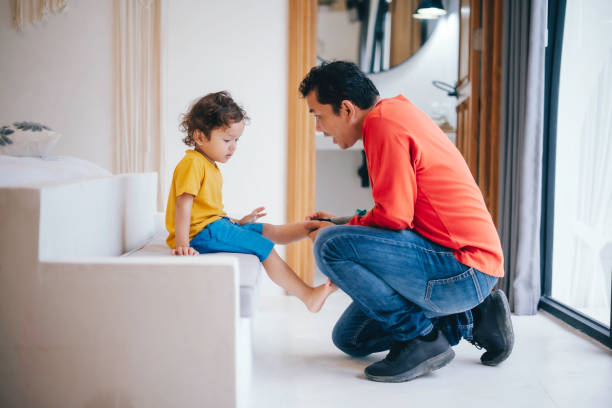 Father helping his son put his shoes on
