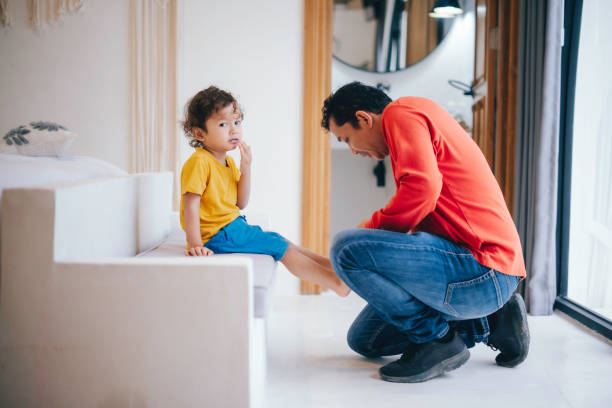istock Father helping his son put his shoes on 1965020978