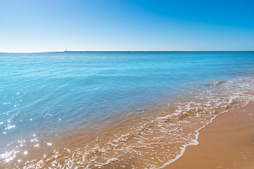 Rock beach, sea, and cloudy blue sky  on the sunny day