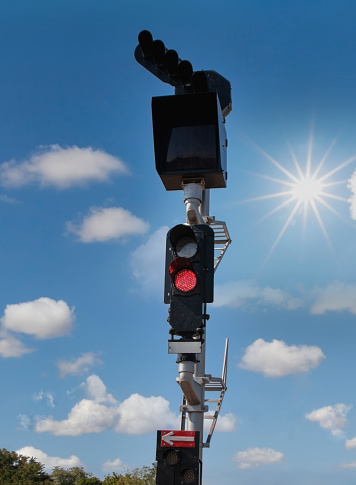 train signal outdoors against the sky with the red light on to stop