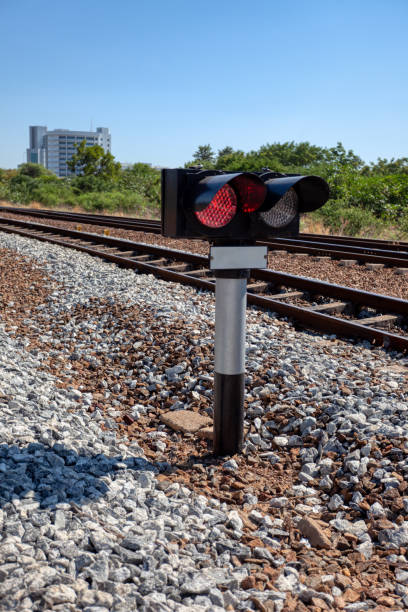 istock train signal outdoors against the sky with the red light on to stop 1965053974