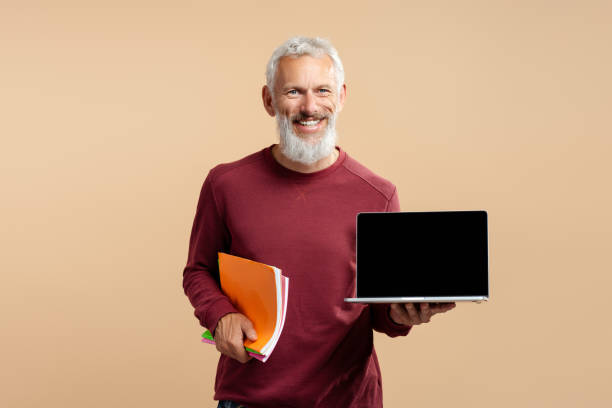 istock Smiling bearded man, mature freelancer holding laptop showing computer screen isolated on background 1965064301