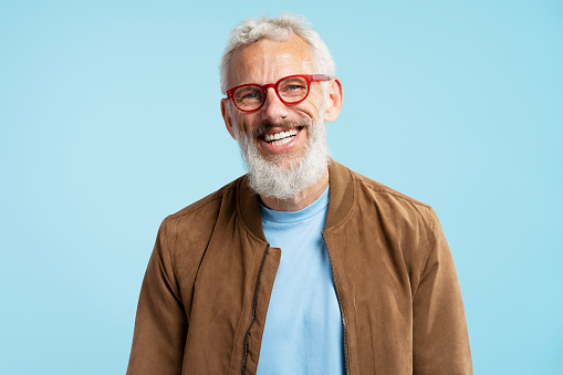 Successful good-looking modern mature businessman leaned on the desk in contemporary office, middle-aged male employee, small business owner, investor in suit looking at the camera, proud entrepreneur