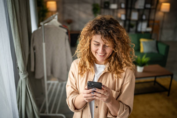 istock Happy beautiful young woman using smartphone typing messages 1965065967