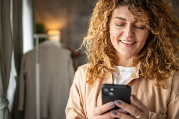 istock Happy beautiful young woman using smartphone typing messages 1965065973