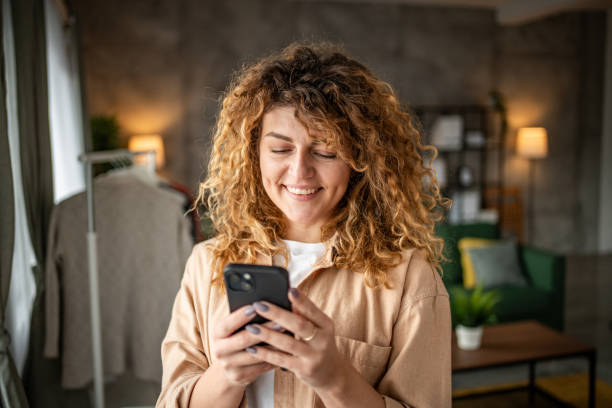 istock Happy beautiful young woman using smartphone typing messages 1965065974