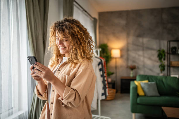 istock Happy beautiful young woman using smartphone typing messages 1965066503