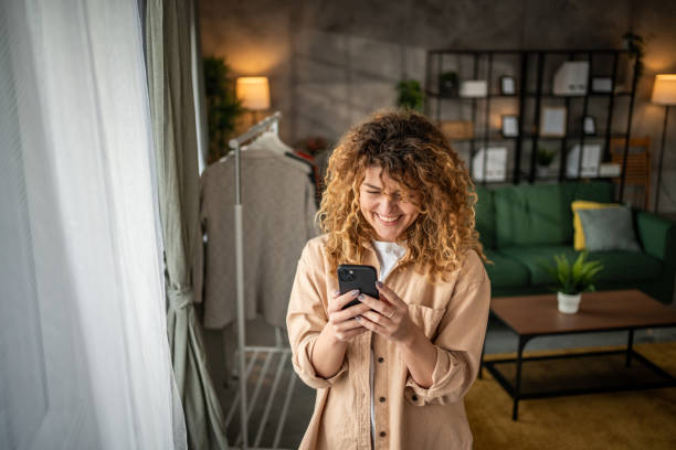 istock Happy beautiful young woman using smartphone typing messages 1965066668