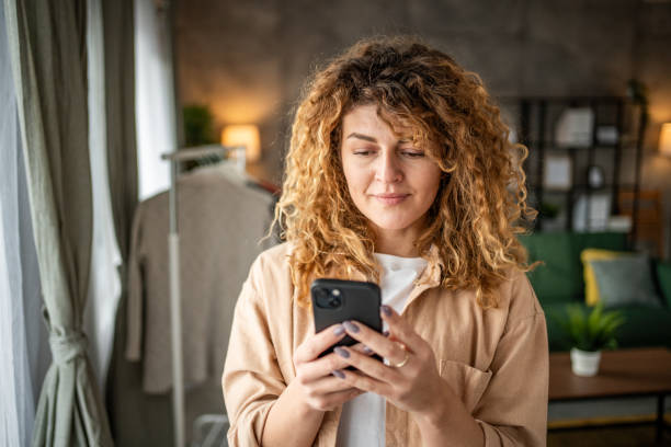istock Happy beautiful young woman using smartphone typing messages 1965067037